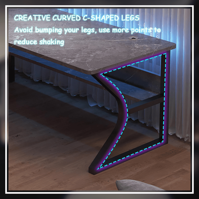 A modern gaming desk setup featuring a sleek, gray desk with a curved black frame. The desk holds a monitor displaying a mountain landscape, a keyboard, a mouse, and various accessories. A gaming PC with blue LED lights is positioned underneath. The wall has a pegboard with a digital clock and other items.