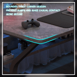 A modern gaming desk setup featuring a sleek, gray desk with a curved black frame. The desk holds a monitor displaying a mountain landscape, a keyboard, a mouse, and various accessories. A gaming PC with blue LED lights is positioned underneath. The wall has a pegboard with a digital clock and other items.