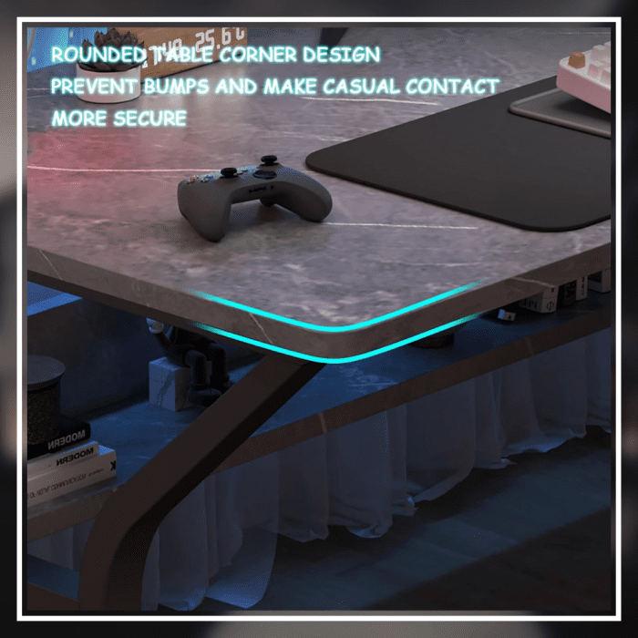 A modern gaming desk setup featuring a sleek, gray desk with a curved black frame. The desk holds a monitor displaying a mountain landscape, a keyboard, a mouse, and various accessories. A gaming PC with blue LED lights is positioned underneath. The wall has a pegboard with a digital clock and other items.